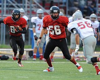 Canfield receiver #89 Andrew Hallof follows the block of teammate #56 Ryan Camardo on Dover linebacker #58 Jordan Doughty on a bubble screen during the first half of a game on September 13, 2013 against Dover.