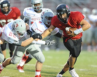 Canfield running back #9 Kimu Kim runs the football breaking the arm tackles of Dover #22Jake Armstrong and #4 Johnny D'egidio. He would score a touchdown on the play during the first half of a game on September 13, 2013 against Dover.
