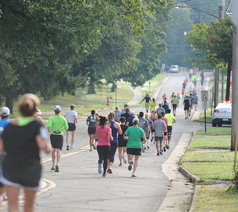 Runners taking part in the half marathon run down McCollum Road early Sunday morning as part of the Green Cathedral race on September 15, 2013.
