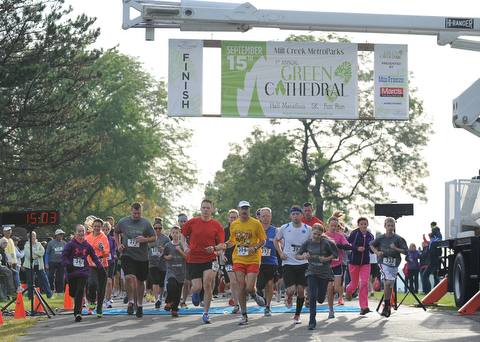 Runners start to run at the beginning of the 5k run early Sunday morning as part of the Green Cathedral race on September 15, 2013.