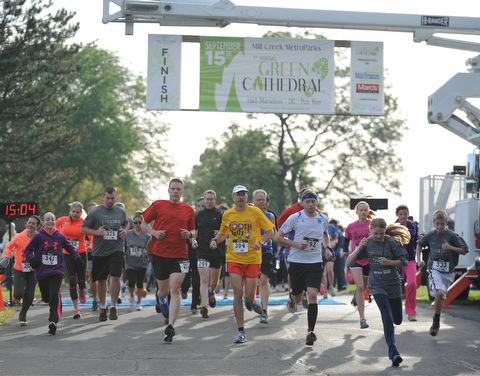 Runners start to run at the beginning of the 5k run early Sunday morning as part of the Green Cathedral race on Sunday September 15, 2013.