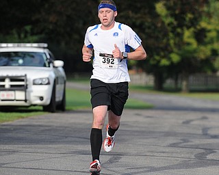 Taylor Millich of Youngstown crosses the finish line to finish first in the 5k run as part of the Green Cathedral race on Sunday September 15, 2013.