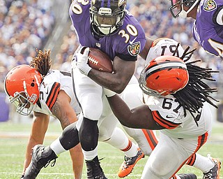 Ravens wide receiver Brandon Stokley plows through Browns defenders Mooney grad Ishmaa’ily Kitchen, (67) and Jabaal Sheard during the second half of their NFL game Sunday in Baltimore. The Ravens defeated the Browns, 14-6.