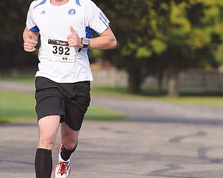 Taylor Millich of Youngstown crosses the finish line to win the 5K portion of Mill Creek Park’s inaugural Green Cathedral 5K and half marathon on Sunday. The event was a benefit for the MetroParks’ new Wick Recreation Area Children’s Playground. 