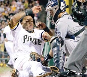 Pittsburgh Pirates’ Marlon Byrd, left, is tagged out by San Diego Padres catcher Nick Hundley while trying to score during the third inning of a game Tuesday in Pittsburgh.