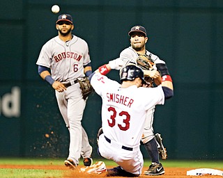Houston Astros second baseman Jose Altuve throws over Cleveland’s Nick Swisher (33) to complete a double play on a ball hit by the Indians’ Jason Kipnis in the third inning of a game Thursday in Cleveland. The Indians won 2-1 in 11 innings.