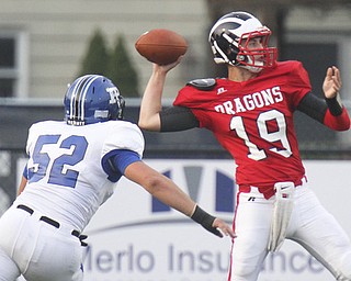 William D. Leiws The Vindicator Niles QB Kyle Paden(19) gets off a first QTR pass as Poland's Mike Audi (52) persues at Niles 9-20-13.
