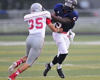 Fitch running back #5 Kerrell Johnson attempts to slip out of a tackle from Dover defensive back #35 Jacob Bambeck  on a running play during the first quarter.