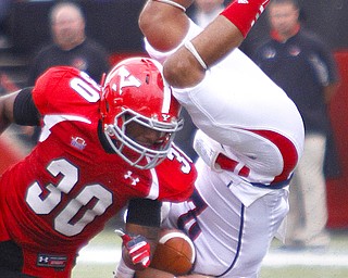 MADELYN P. HASTINGS | THE VINDICATOR..Duquesne's Carter Gianni (2) flips over YSU's John Medina (30) and Dale Peterman (21) during their game at Stambaugh Stadium on Saturday, September 21. .... - -30-..