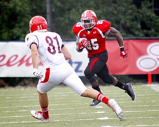 MADELYN P. HASTINGS | THE VINDICATOR..YSU's Torrian Pace (25) runs with the ball while Duquesne's E.J. Kosec (31) attempts to stop him during their game at Stambaugh Stadium on Saturday, September 21. .... - -30-..