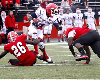 MADELYN P. HASTINGS | THE VINDICATOR..YSU's Jameel Smith (26) pulls Duquesne's Chris Johnson (4) down to the ground while YSU's Adaris Bellamy (13) looks on during their game at Stambaugh Stadium on Saturday, September 21. ... - -30-..