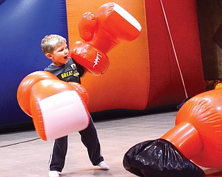 Ryan Gray wears mega-size boxing gloves to punch a big bag at a recent fun day kick-off for Promiseland Children’s Ministry at Wedgewood Park Church, 1944 S. Meridian Road, Austintown. The 4-year-old was with his grandfather, Bob Gray, who said, “He’s having a blast.”