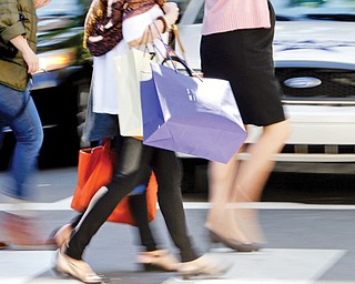 Pedestrians with shopping bags cross a street recently in Philadelphia. The private Conference Board reported on consumer confidence for September on Tuesday.