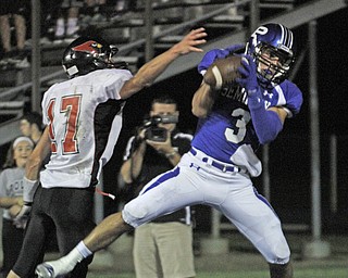 . ROBERT K. YOSAY | THE VINDICATOR..Polands #3 Tyler Evan pulls in a second quarter pass as Canfields #17 Aaron Jenkins tries to defend..Canfield at Poland