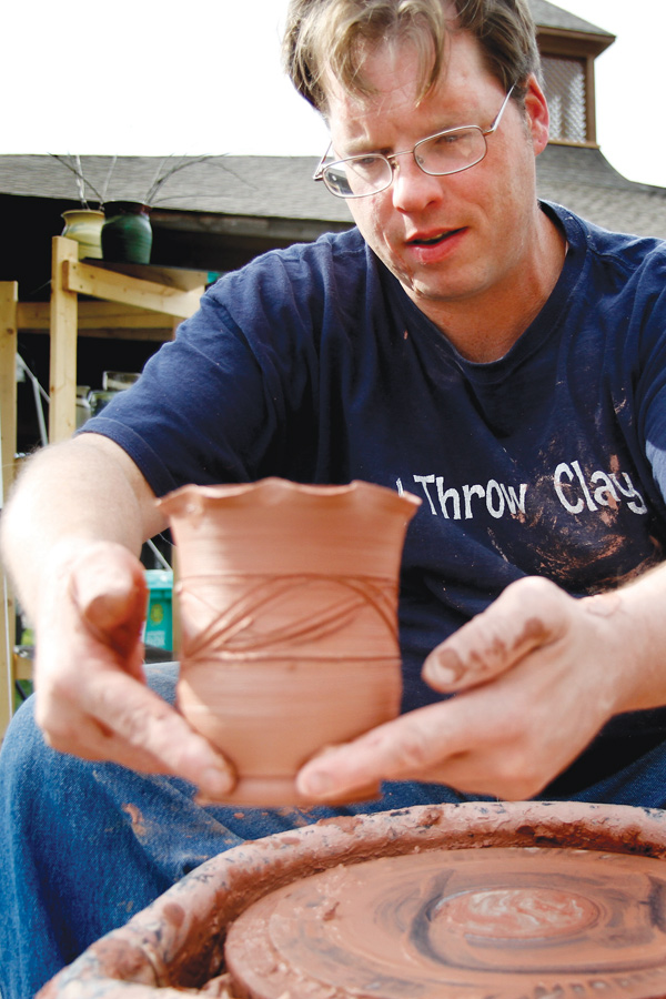 Chris Karg with Karg Pottery works on a piece of art at Sunday’s Oktoberfestival arts and crafts show in Boardman Park.