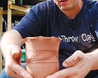 Chris Karg with Karg Pottery works on a piece of art at Sunday’s Oktoberfestival arts and crafts show in Boardman Park.