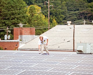 Mike Easterwood checks one of the solar panels installed on the roof of his 1947-era building in Decatur, Ga. Easterwood paid about $320,000 to install nearly 400 solar panels on top of his self-storage business near Atlanta.
