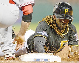 The Pirates’ Andrew McCutchen dives back to first on a pickoff attempt in the fourth inning of the NL wild-card game against the Cincinnati Reds on Tuesday night. The Pirates won, 6-2.