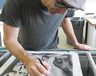 Using granite limestone as his canvas, YSU student Christopher Bosi sketches a drawing for a lithograph.