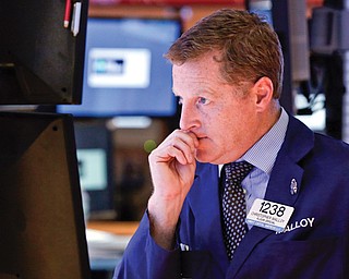 Trader Christopher Malloy works on the floor of the New York Stock Exchange on Wednesday. The stock market closed slightly lower as investors weigh the possibility that political gridlock may keep the government partially closed for some time.