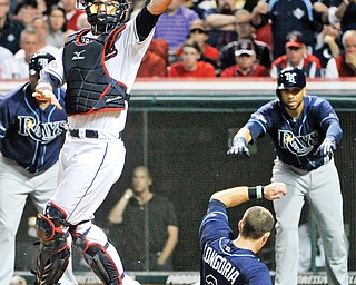 Indians catcher Yan Gomes leaps for the high throw as the Rays’ Evan Longoria (3) slides into home to score on a two-run double by Desmond Jennings during the fourth inning of the AL wild-card playoff game Wednesday at Progressive Field in Cleveland. The Rays eliminated the Indians from post-season play with a xx-xx win.