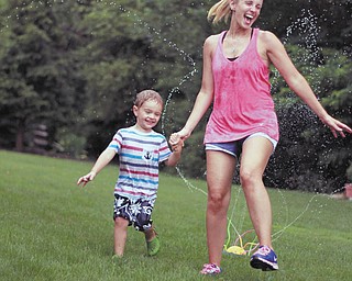 Three-year-old Sam Manning and his mommy, Samantha Manning, are having fun in the sprinkler on a hot day. Sent by grandmother of Sam, Joyce Buzzacco.