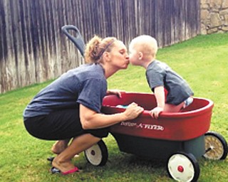 Colton, 2, gives Aunt Laurie a kiss for giving him wagon rides in the backyard while she was visiting him in Arlington, Texas.