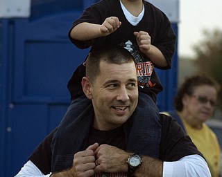 Kelli Cardinal/The Vindicator .Sean Reilly, 5, from Mineral Ridge, dances on his dad, Kevin's, shoulders Friday while they listen to the Mineral Ridge High School band before the game against McDonald at Whittaker Field.