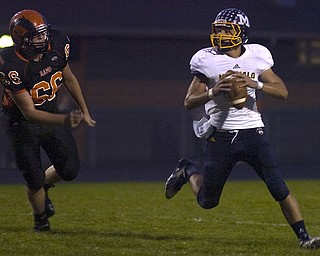 Kelli Cardinal/The Vindicator .McDonald quarterback Ben Carkido looks to pass Friday while avoiding the sack by Mineral Ridge defender Zane Rummel at Whittaker Field.