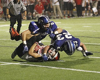. ROBERT K. YOSAY | THE VINDICATOR..#23 Adam Wollet and#6 Geno Petrus catches #3 Struthers Dalton Moore for a big loss as they had driven to the 4 yard line but were stopped by the poland defense..Poland vs Struthers @ Poland