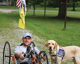 MADELYN P. HASTINGS | THE VINDICATOR..Brett Clingan of Champion has a neurological disorder but is still competing in the Peace Race using a hand cycle and the help of his Labrador Golden Retriever, Albus.... - -30-..