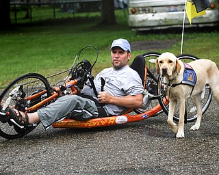 MADELYN P. HASTINGS | THE VINDICATOR..Brett Clingan of Champion has a neurological disorder but is still competing in the Peace Race using a hand cycle and the help of his Labrador Golden Retriever, Albus.... - -30-..