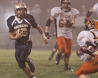. ROBERT K. YOSAY | THE VINDICATOR..Lowellville #16 picks out a line as he makes a first down during third quarter action at Lowellville - behind hims is Wellsville #60 Levy Brown and #16 Jordan Allen