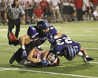 . ROBERT K. YOSAY | THE VINDICATOR..#23 Adam Wollet and#6 Geno Petrus catches #3 Struthers Dalton Moore for a big loss as they had driven to the 4 yard line but were stopped by the poland defense..Poland vs Struthers @ Poland