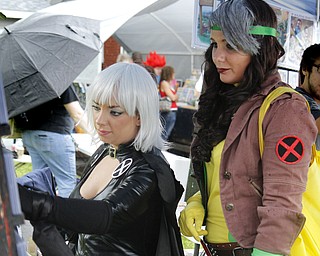 MADELYN P. HASTINGS | THE VINDICATOR..(L-R) Stephanie Karasevich, dressed as X-Men's Storm, and Riley Rivera, dressed as X-Men's Rogue, both of Cleveland, look at comic book collectables at the fourth annual Lawn-Con on the west side on Saturday, October 5, 2013. ... - -30-..