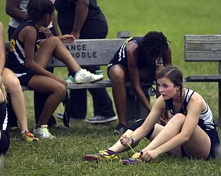 Kelli Cardinal/The Vindicator .Stephanie Waltman, a junior from Austintown Fitch, rests and ties her shoe Saturday after competing in the boys and girls Division I open race during the Legends Cross Country Meet at Trumbull County Fairgrounds.