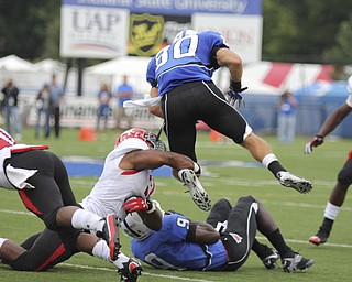Youngstown State's Teven Williams wraps up the leg of Indiana State's Tanner Riley (80) during the first quarter of Saturday's matchup at Indiana State. Dustin Livesay | The Vindicator 10/05/13 Indiana State University, Terre Haute, Indiana.