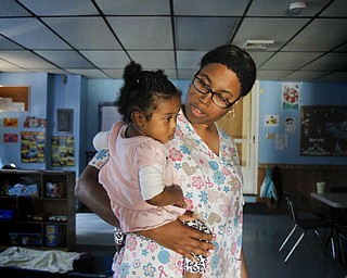 MADELYN P. HASTINGS | THE VINDICATOR..Vonetta Davis holds 1 year old Alexia Moorer in Banana Darlings Learning Center on YoungstownÕs East Side. Davis has worked with children for more than 20 years, but this is her first business venture. ... - -30-..