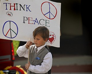 MADELYN P. HASTINGS | THE VINDICATOR..Chase Britton, 6, of Youngstown holds a sign that reads "Think Peace" in the third annual nonviolence parade to kick off nonviolence week in downtown Youngstown on Sunday, October 6, 2013.... - -30-..