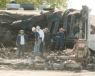 Boardman Fire Chief George D. Brown, in white shirt, arson investigators and investigators from the state fire marshal’s office sift through the rubble after a fire at the Spice of India restaurant on Market Street.