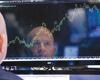 Specialist Jay Woods is reflected in a screen at his post on the floor of the New York Stock Exchange on Thursday. Wall Street roared in approval Thursday after Washington appeared to break an impasse that threatened to push the country into default.