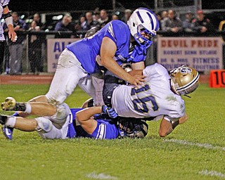 . ROBERT K. YOSAY | THE VINDICATOR..sacked and then some as Lowellvilles quarterback is brought down for a big loss during third quarter action by WR # 54 Parker Clegg and on the bottom #44 Dan Zilke..Lowellville at Western Reserver