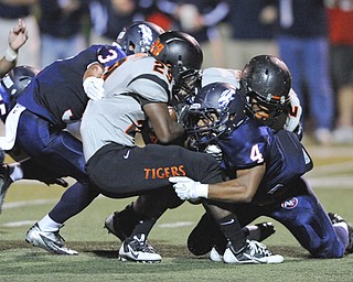 Massillon running back #29 Lyron Wilson is tackled by Fitch #4 Gary Gibson and #31 Tyler Hewlett in the backfield for a 3 yard loss on a run play on a play in the first quarter.
