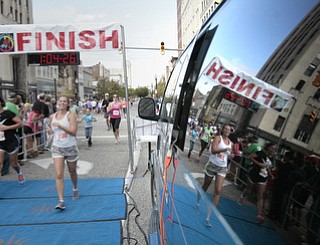 . ROBERT K. YOSAY | THE VINDICATOR..Mirror finish.. two runner s cross the line with the reflection in the glass..The 39th Annual Peace Race - with over 2000 runners on a beautiful October day