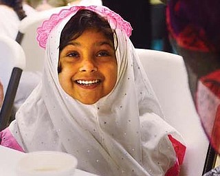 Zainab Rehman, 4, of Boardman, is excited as her mother puts on the scarf she purchased for her at an open house at the Masjid Al-Khair mosque in Youngstown on Sunday. The open house was the mosque’s fifth and showcased a variety of ethnic foods, customs and information on Islam.