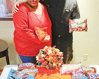 Victoria Allen, president of ICU Block Watch, and the Rev. Greg Maturi, pastor of St. Dominic Church in Youngstown, show some of the candy being collected for distribution at the Neighborhood Harvest. The event is planned from 3 to 5 p.m. Sunday in the gated lot at the corner of Cottage Grove and Auburndale Avenue in Youngstown.