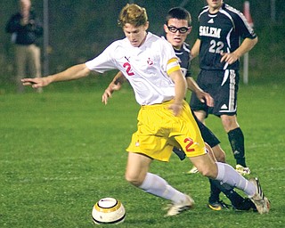 Cardinal Mooney’s Clayton Walker fights to stay in control of the ball against Salem defender Mike Anzevino during a Division II sectional match Tuesday night. Mooney won, 6-0, and will meet Lakeview on Saturday night.