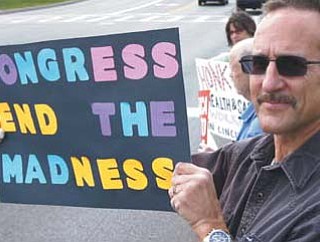 Steven Ahrenholz, a furloughed federal worker, protests outside the Department of Health and Human Services CDC offices in Cincinnati.