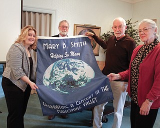 Members of the Friends of Mary B. Smith Committee, from left, Kristen Olmi, Rick Shale, Jim Ray and Judith Stanger, show the banner that will be displayed on the landing of the main stairway from DeBartolo Hall’s second floor to the lobby in the College of Liberal Arts and Social Sciences at Youngstown State University.
