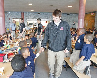 Alex Smith of the Youngstown Phantoms shakes hands and bumps fists with students in grades K-2 during lunch at the Horizon Science Academy in Youngstown. Smith and teammates Ryan Schwalbe and Kiefer Sherwood visited the school as part of an outreach program with Youngstown City Schools.